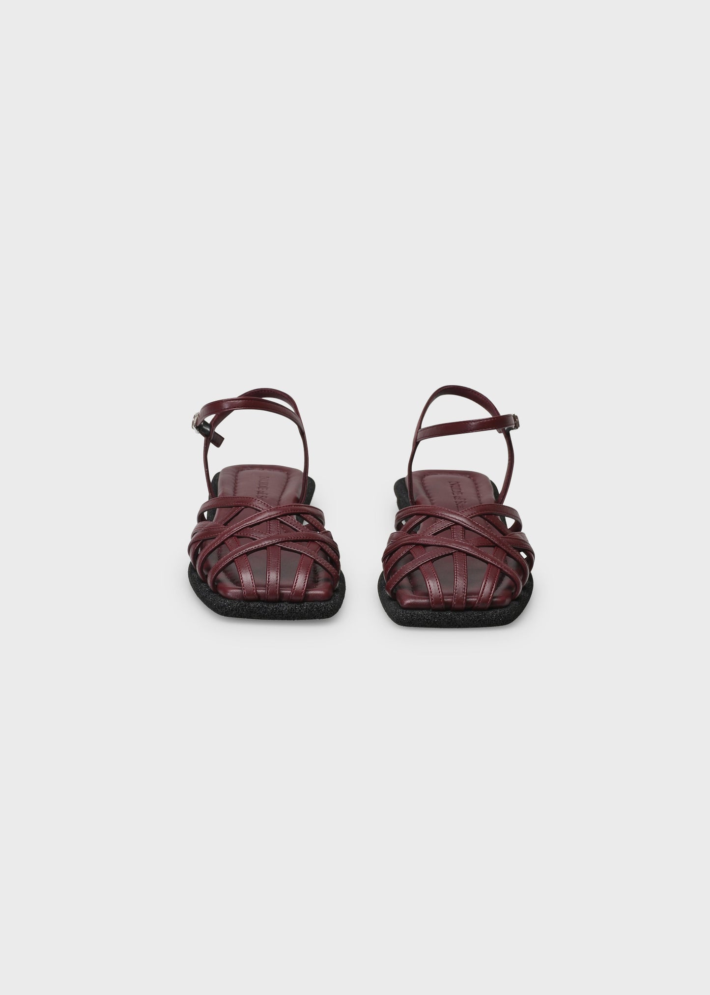 Pair of maroon sandals on a light gray background