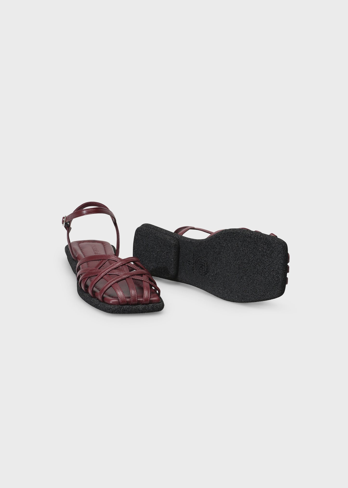 Maroon sandal with a black sole on a light gray background