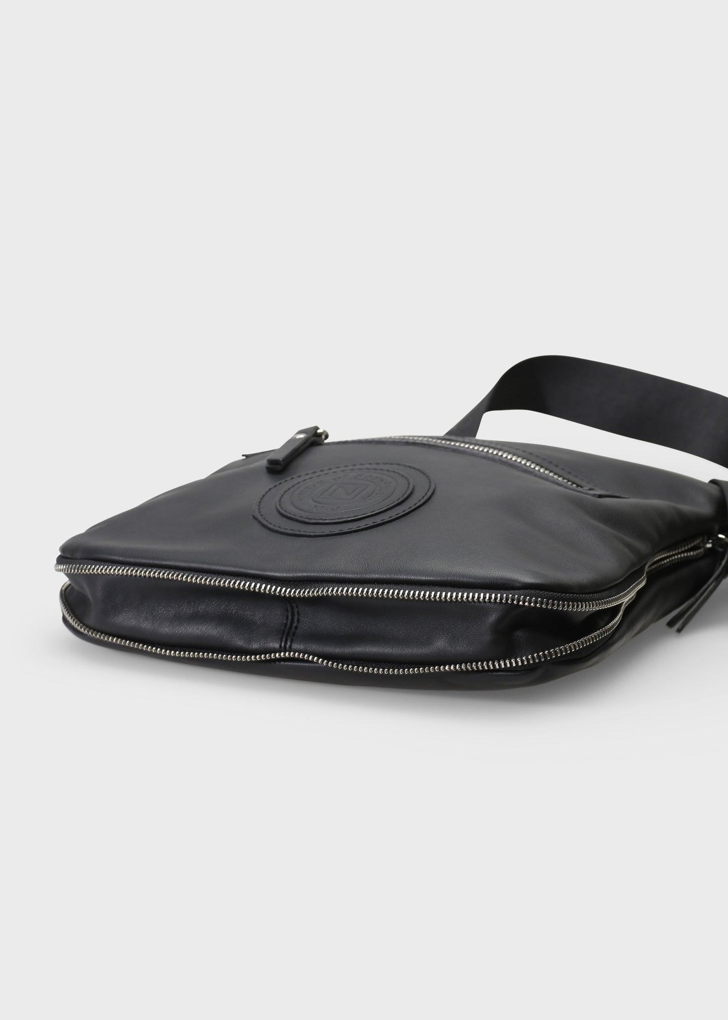 Black leather bag with a visible brand logo on a light gray background