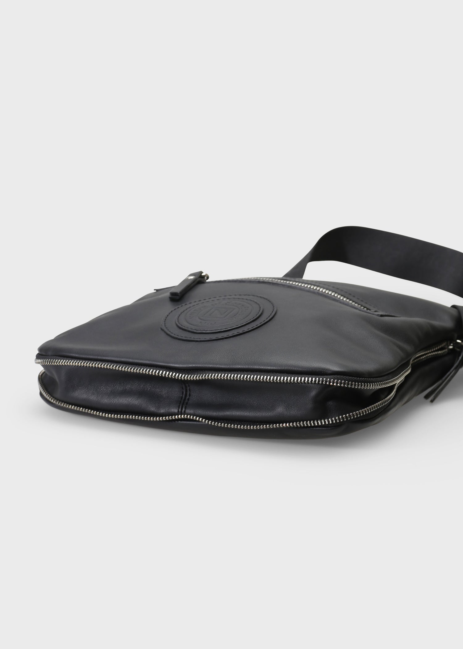 Black leather bag with a visible brand logo on a light gray background