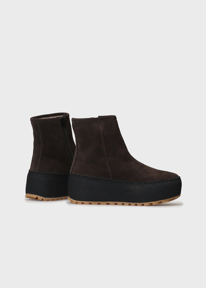 Pair of brown platform ankle boots on a light gray background